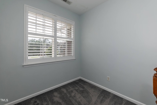 empty room with dark colored carpet