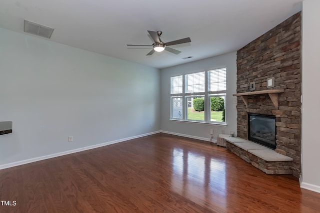 unfurnished living room with a fireplace, dark hardwood / wood-style floors, and ceiling fan