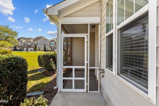 view of exterior entry featuring a yard