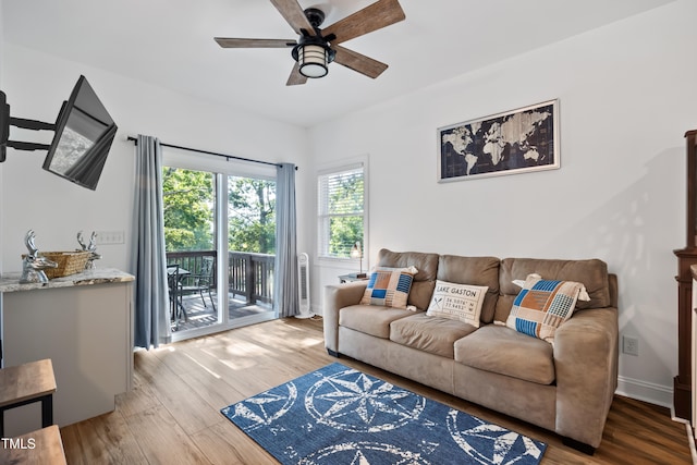 living room featuring ceiling fan and hardwood / wood-style flooring