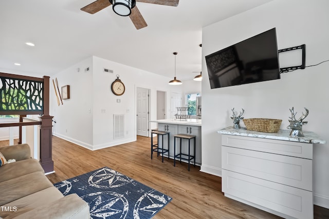 living room with ceiling fan and light hardwood / wood-style flooring