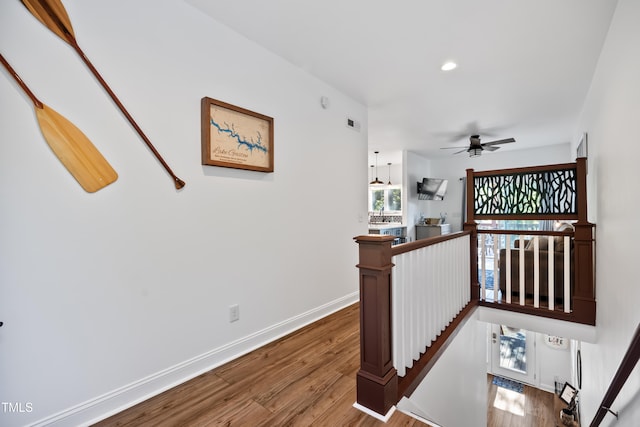 stairway with ceiling fan and hardwood / wood-style flooring