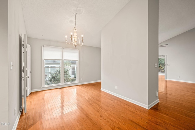 interior space featuring a chandelier, a textured ceiling, light hardwood / wood-style floors, and lofted ceiling