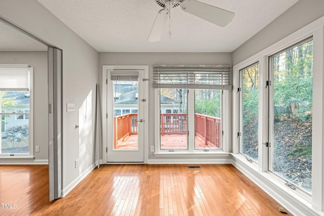 unfurnished sunroom with plenty of natural light and ceiling fan