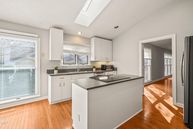 kitchen with white cabinetry, stainless steel appliances, and a wealth of natural light