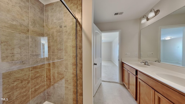 bathroom with a tile shower and vanity