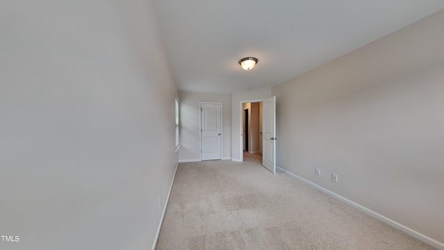 unfurnished room featuring light colored carpet