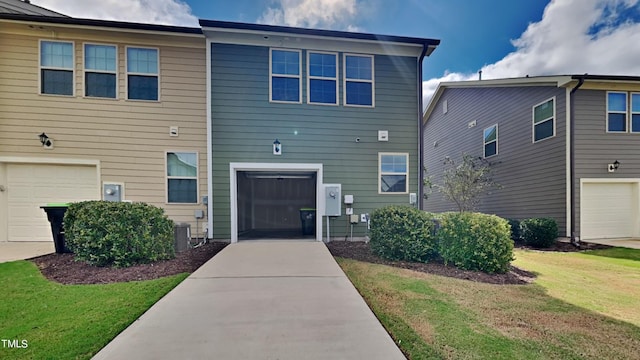 view of front facade featuring a garage, central air condition unit, and a front yard