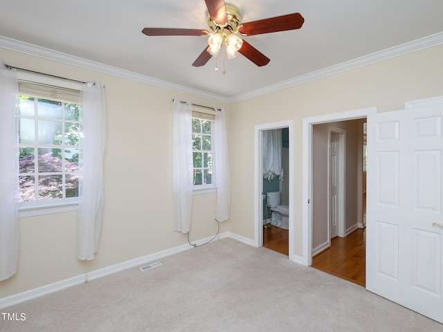 unfurnished bedroom featuring connected bathroom, ceiling fan, light carpet, and ornamental molding