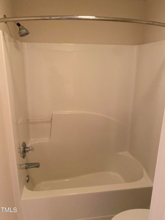 bathroom with toilet and shower / washtub combination