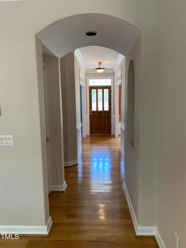 hallway with hardwood / wood-style floors and ornamental molding