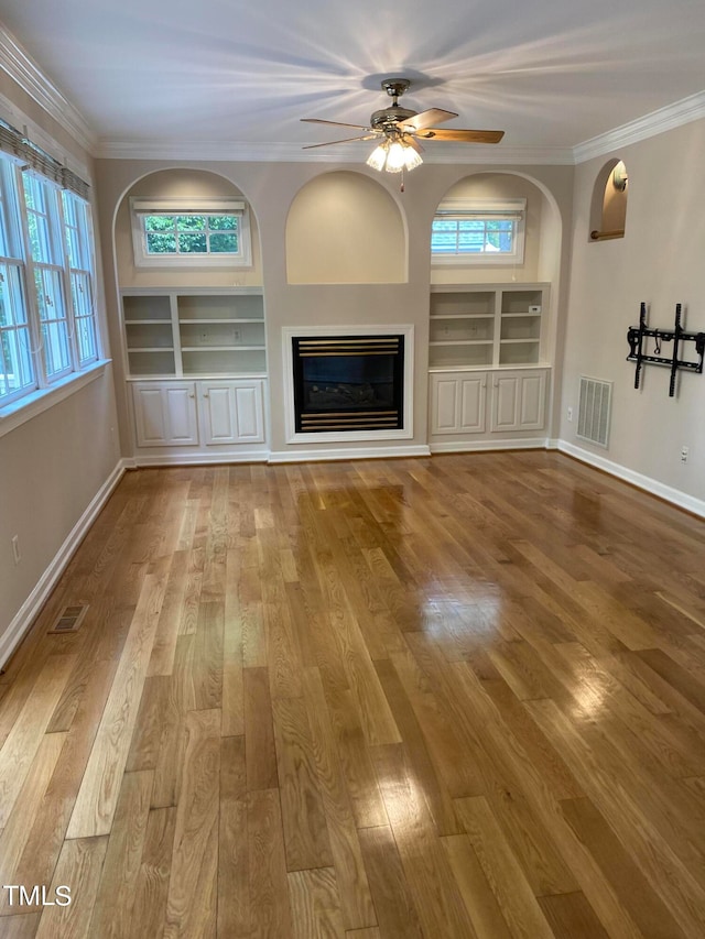 unfurnished living room with hardwood / wood-style floors, ceiling fan, and ornamental molding