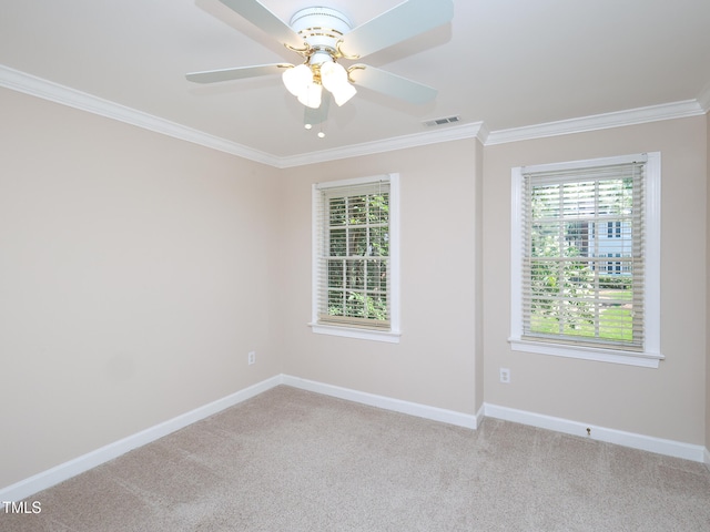 carpeted empty room featuring ceiling fan, a healthy amount of sunlight, and ornamental molding