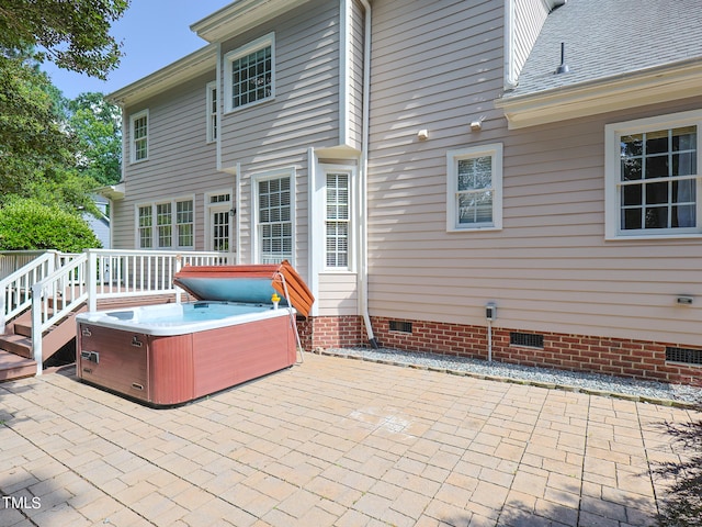 rear view of property featuring a patio and a hot tub