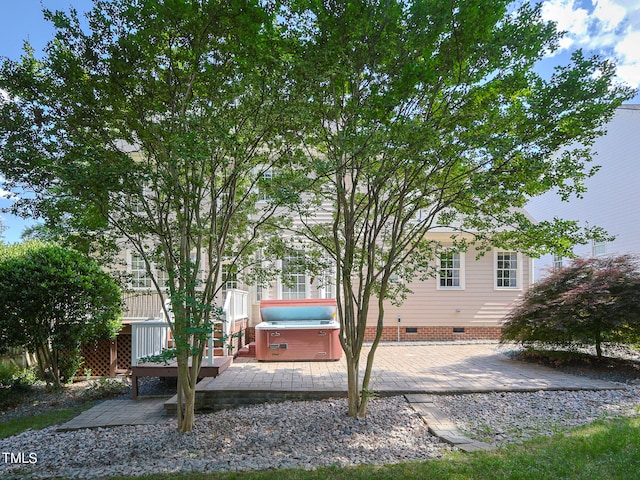 view of yard with a wooden deck, a patio, and a hot tub