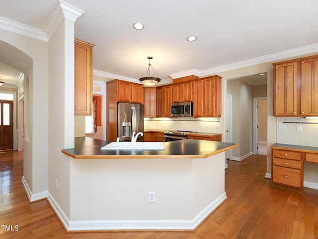 kitchen with stainless steel appliances, kitchen peninsula, light hardwood / wood-style floors, decorative backsplash, and ornamental molding