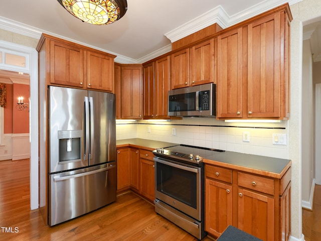 kitchen featuring appliances with stainless steel finishes, tasteful backsplash, light hardwood / wood-style flooring, and crown molding