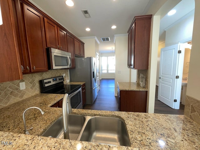 kitchen featuring light stone counters, dark hardwood / wood-style flooring, ornamental molding, and appliances with stainless steel finishes