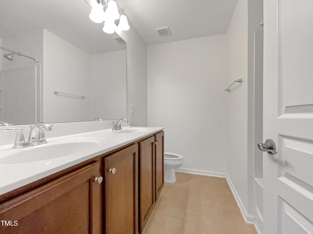 bathroom with toilet, vanity, and tile patterned floors