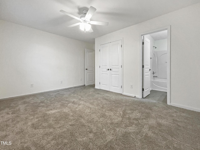 unfurnished bedroom featuring connected bathroom, ceiling fan, and dark colored carpet