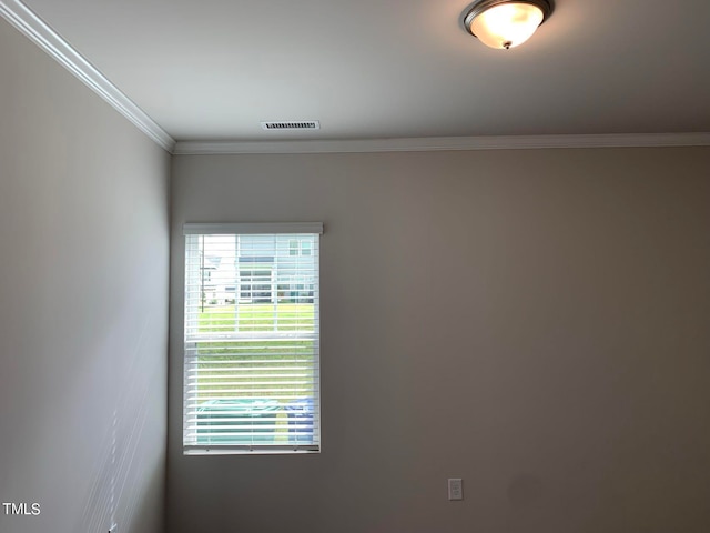 empty room featuring crown molding