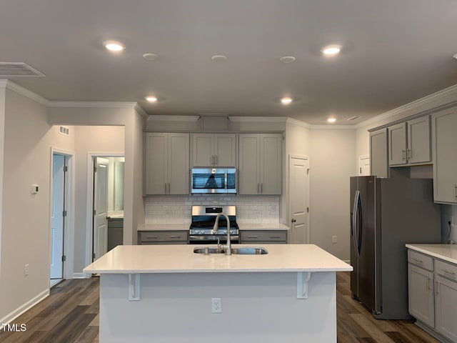 kitchen with a center island with sink, stainless steel appliances, and dark hardwood / wood-style flooring