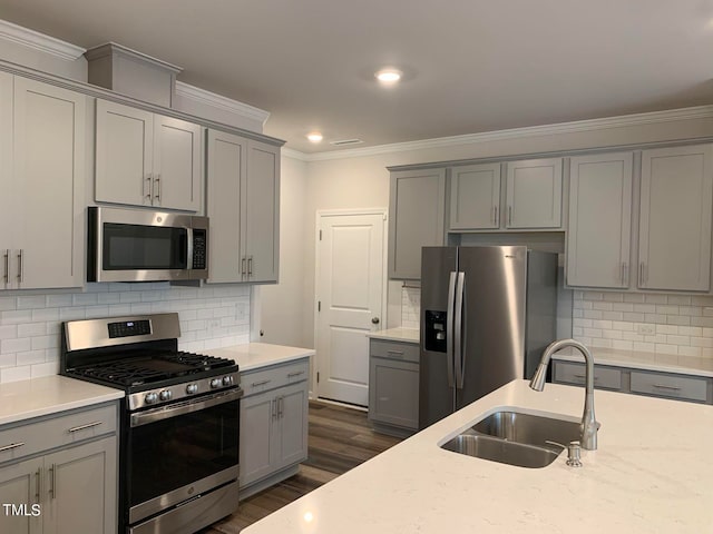 kitchen featuring light stone counters, decorative backsplash, stainless steel appliances, sink, and dark hardwood / wood-style flooring