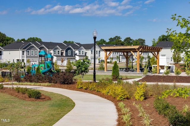 surrounding community featuring a playground, a yard, and a pergola