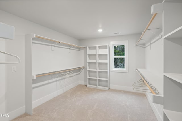 walk in closet featuring light colored carpet