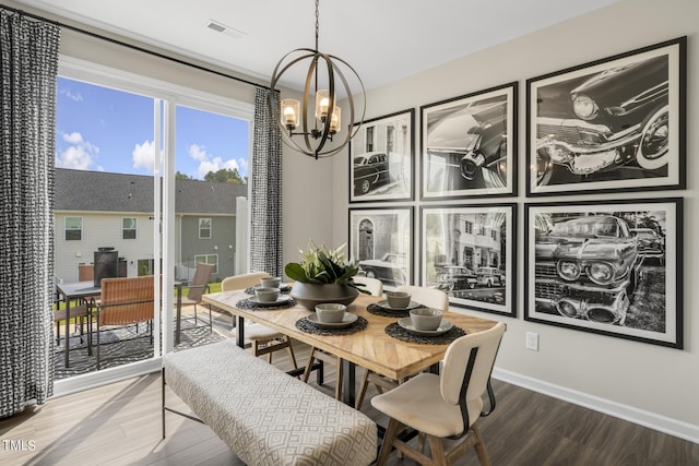 dining space with wood-type flooring and a notable chandelier