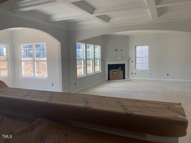 living room with beamed ceiling, carpet flooring, a healthy amount of sunlight, and coffered ceiling