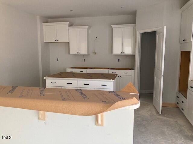 kitchen featuring white cabinets, a kitchen breakfast bar, and a kitchen island