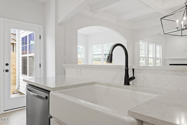 kitchen with a wealth of natural light, sink, dishwasher, and decorative light fixtures