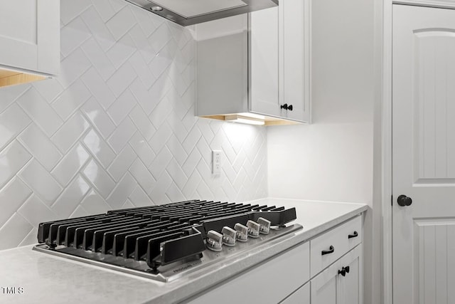 kitchen featuring decorative backsplash, white cabinetry, and stainless steel gas cooktop