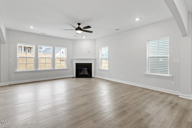 unfurnished living room with light hardwood / wood-style floors, plenty of natural light, and ceiling fan