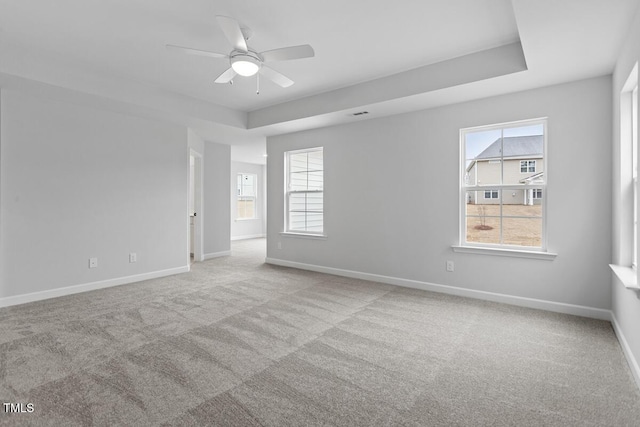 unfurnished room featuring ceiling fan, light carpet, and a healthy amount of sunlight