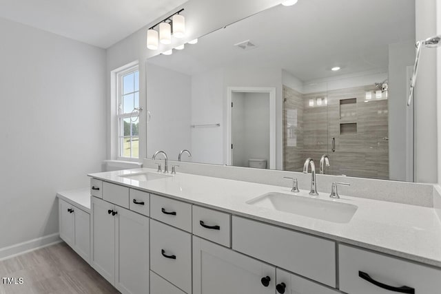 bathroom featuring vanity, toilet, and a shower with door