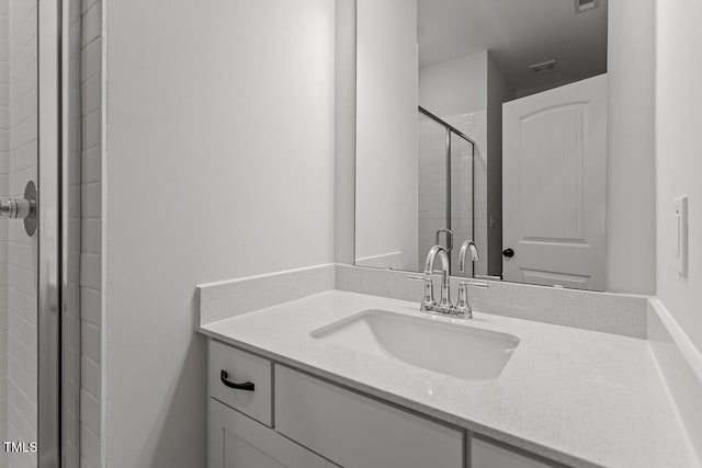 bathroom featuring vanity and a shower with door