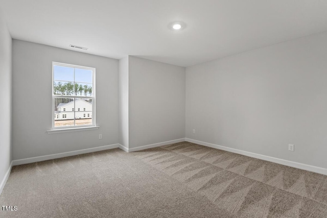 unfurnished room featuring light carpet