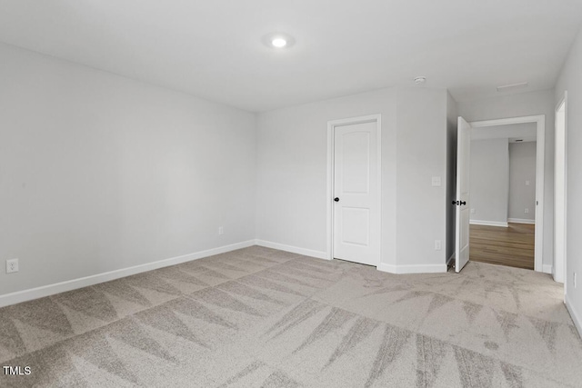 spare room featuring light colored carpet