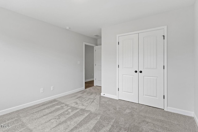 unfurnished bedroom with a closet and light carpet