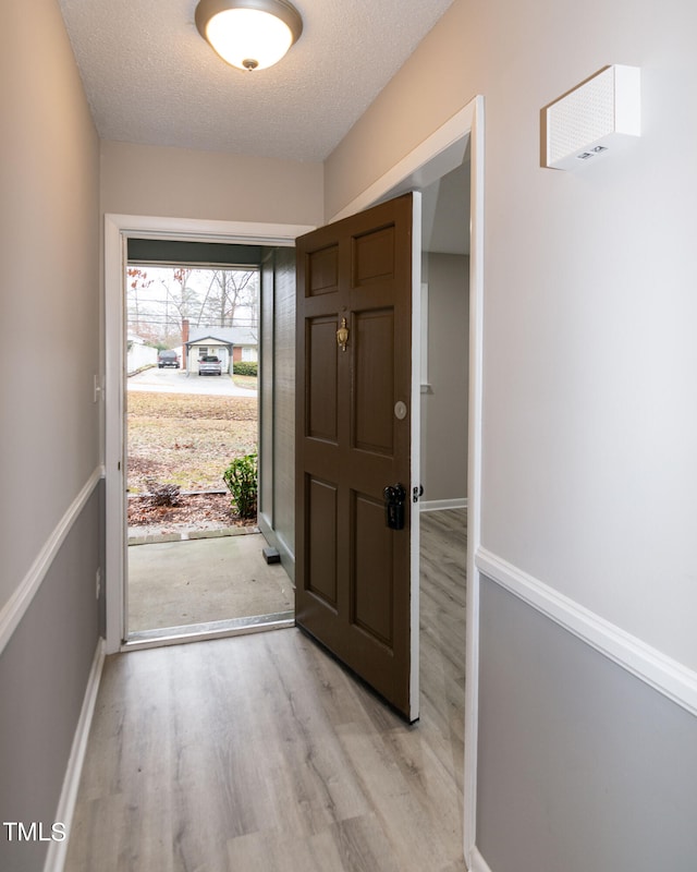 entryway featuring a textured ceiling and light hardwood / wood-style flooring