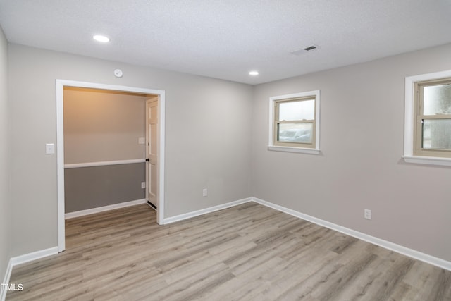 spare room with light hardwood / wood-style flooring and a textured ceiling