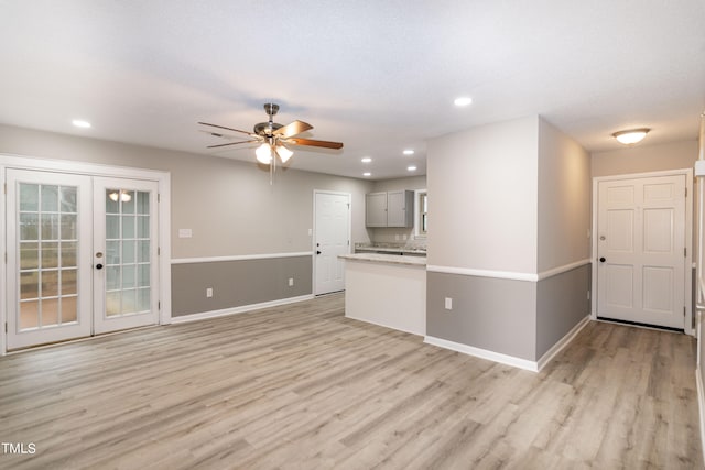 unfurnished living room featuring ceiling fan, light hardwood / wood-style flooring, and french doors