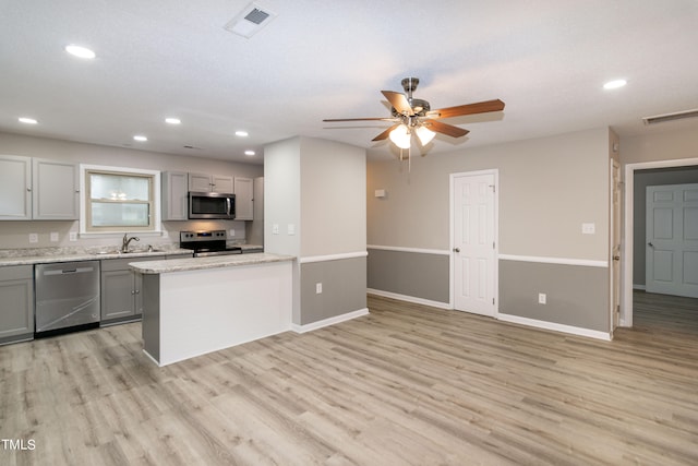 kitchen featuring gray cabinets, stainless steel appliances, and light hardwood / wood-style flooring