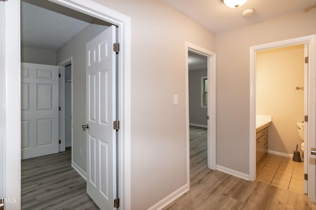 hall with a textured ceiling and hardwood / wood-style flooring