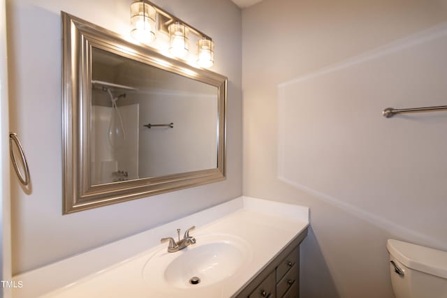 bathroom with vanity, a shower, and toilet