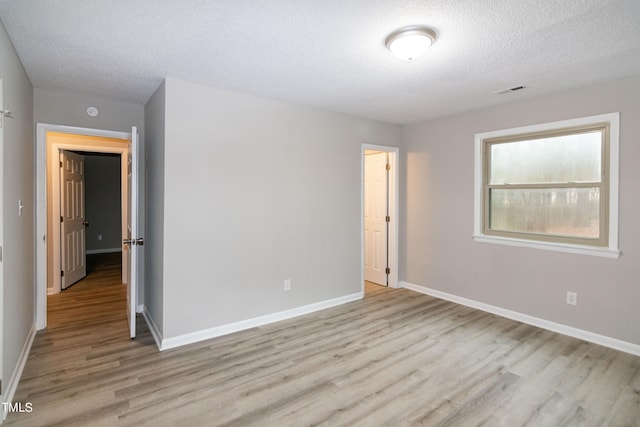 unfurnished bedroom featuring light hardwood / wood-style flooring and a textured ceiling