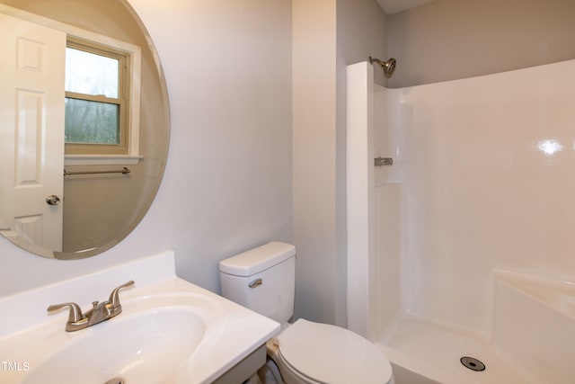 bathroom with vanity, a shower, and toilet