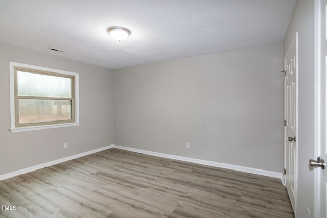 unfurnished room featuring a textured ceiling and wood-type flooring